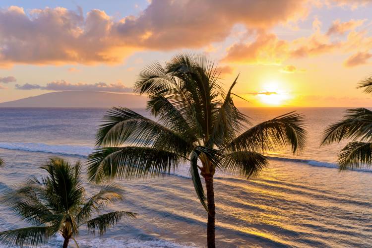 A colorful sunset at north-west coast of Maui, with Lanai island in the background. Maui, Hawaii, USA.