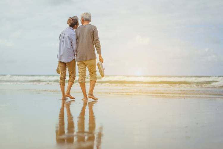 An elderly couple walking on the beach