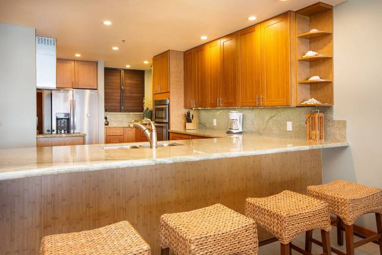 spacious modern kitchen with a bar and good lighting, in a maui vacation rental managed by sullivan properties