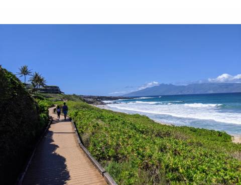 Kapalua Coastal Trail Two children are walking on the Kapalua Coastal Trail, with beautiful Ironwood beach and a view on the island of Molokai on the right of the trail
