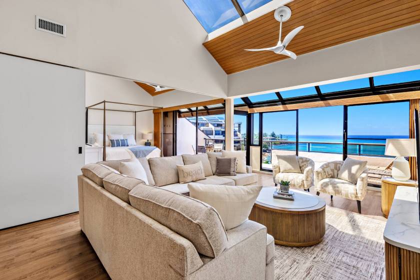 Airy living room with large windows at Sands of Kahana resort. A sliding door opens to a master bedroom